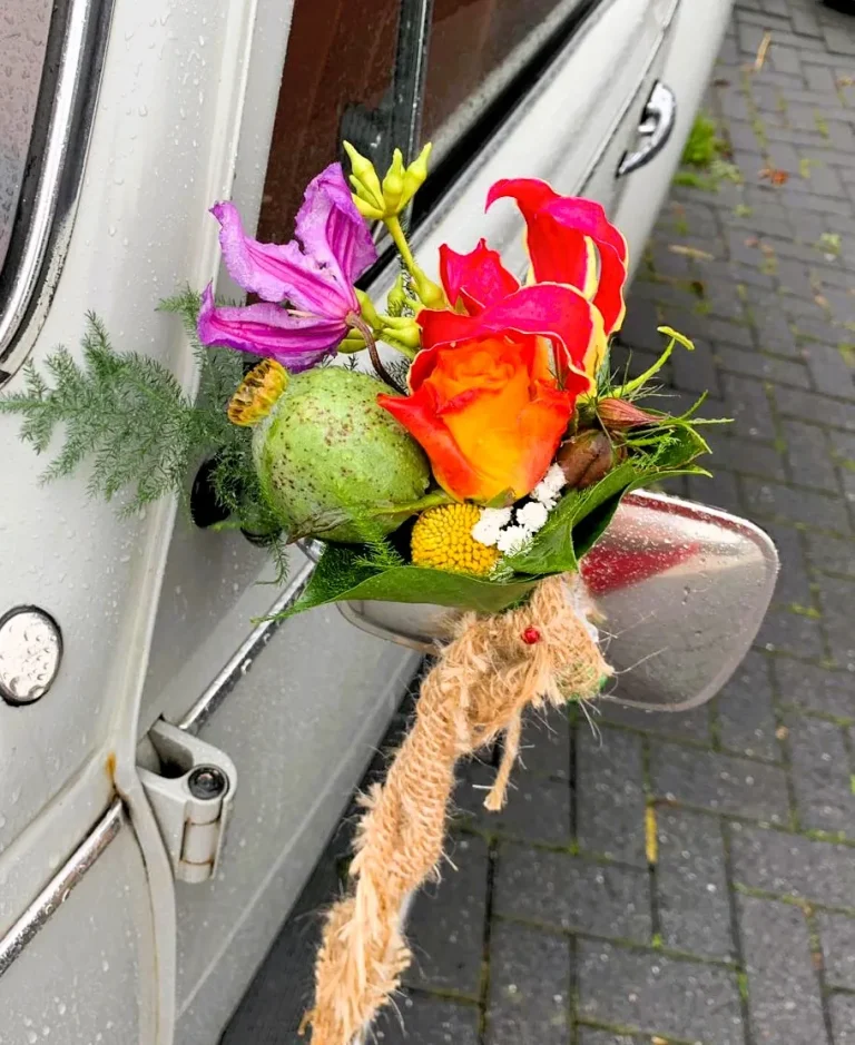 Bloemstuk aan de spiegel van een trouwauto – Bloem en Atelier Floriante