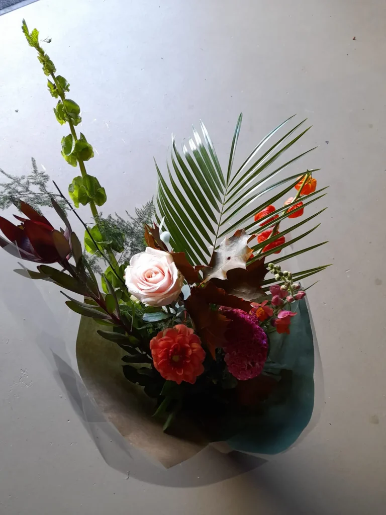 Boeket met rozen en palmblad in folie – Bloem en Atelier Floriante