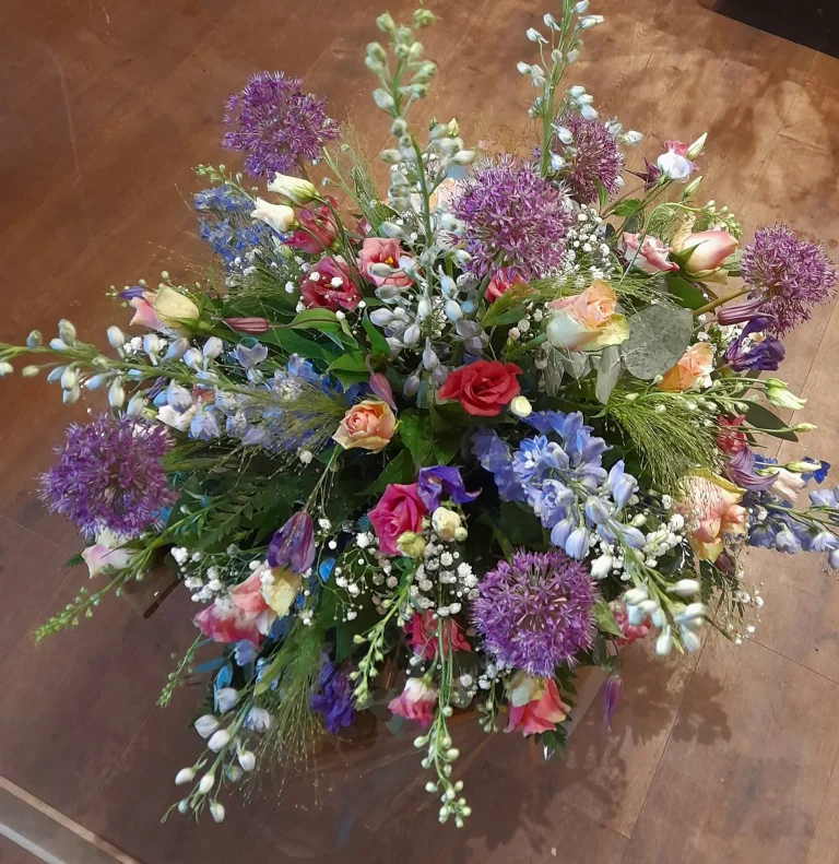 Kleurrijk rouwstuk met allium en ridderspoor – Bloem en Atelier Floriante