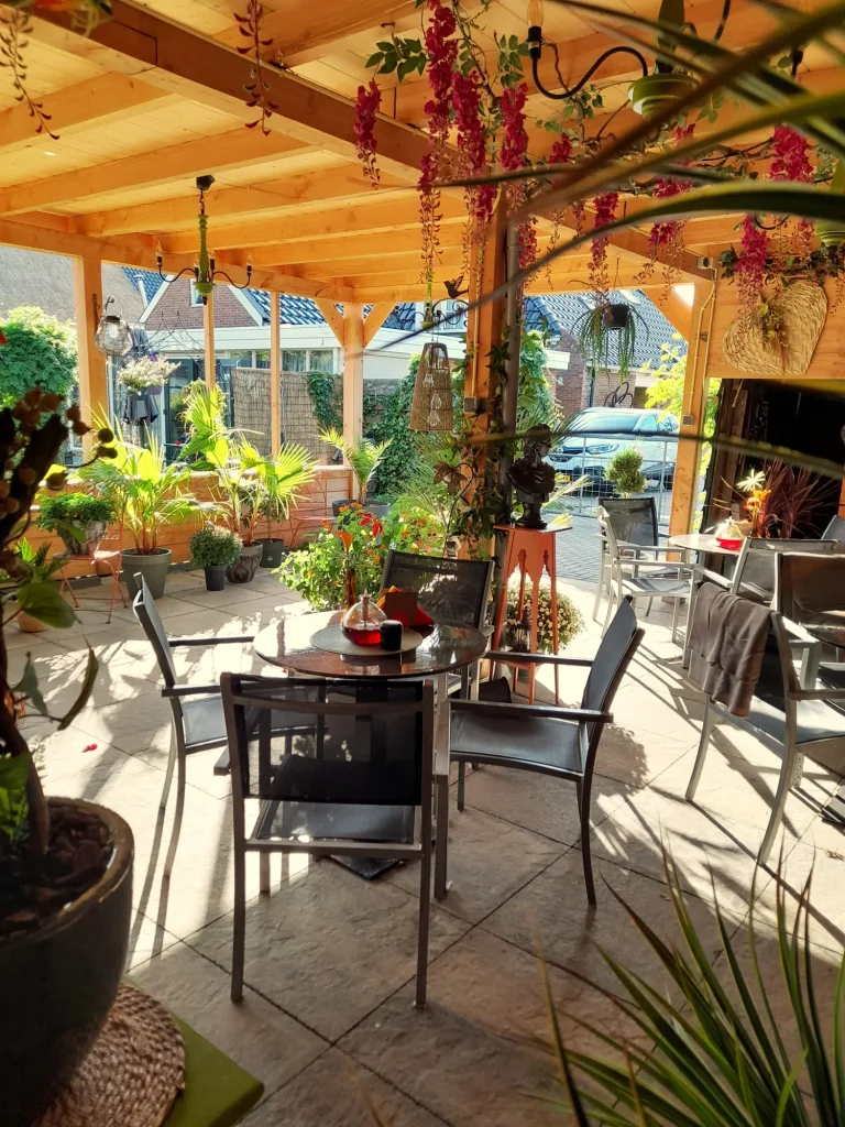 Terras met tafeltjes en hangende bloemen – Bloem en Atelier Floriante
