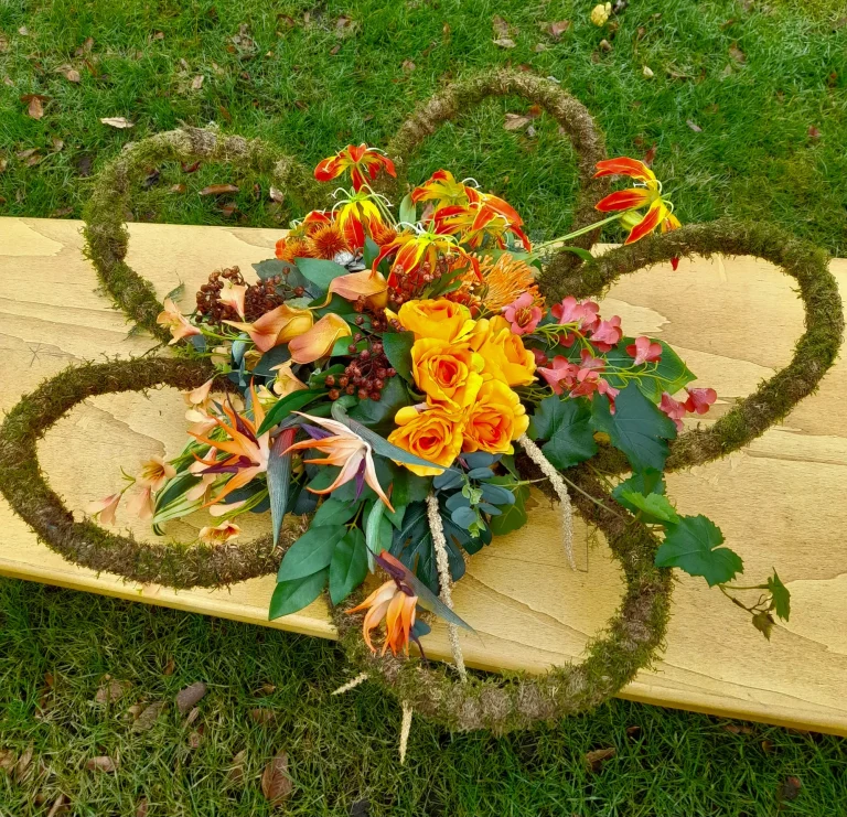 Zijden rouwstuk met krans van mos en oranje bloemen – Bloem en Atelier Floriante