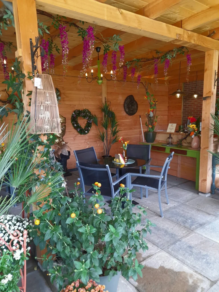 Zitje op het bloementerras tussen bloeiende planten – Bloem en Atelier Floriante